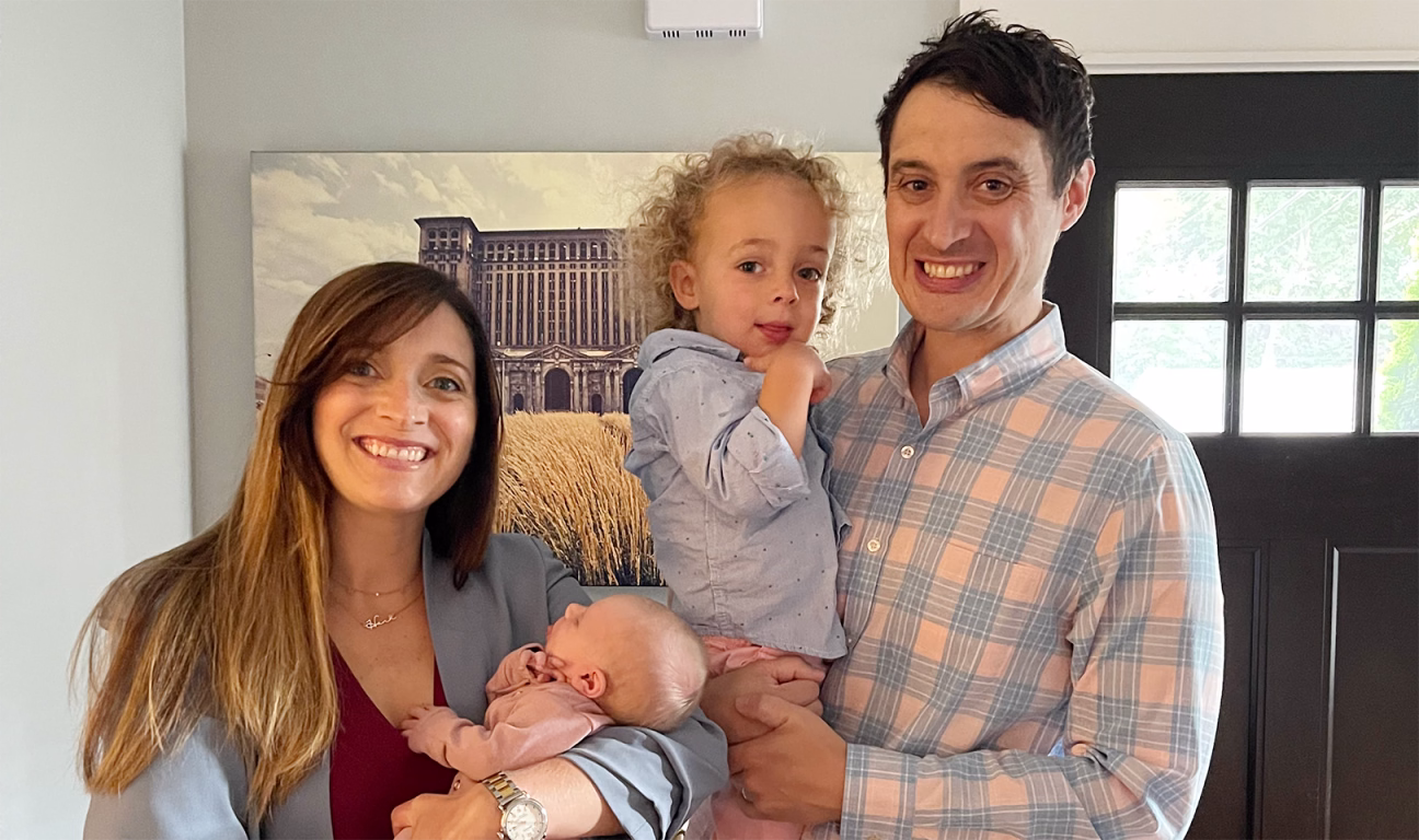 Photograph of two parents, each holding a child.