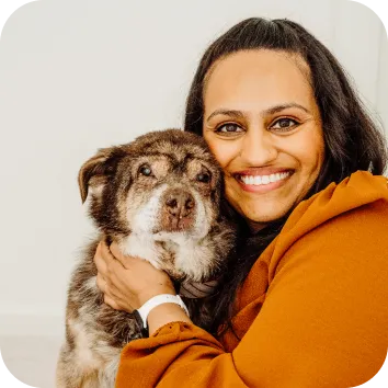 Photo of a woman holding a dog close to her face