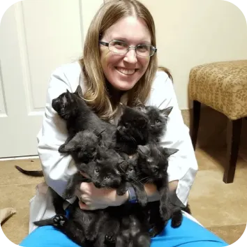 Photo of veterinarian Kristen Dewey holding an armful of kittens