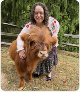 Photo of Dr. Sam Cantor with a highland cow.