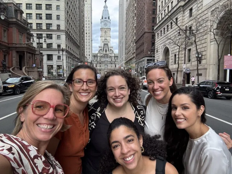 6 members of the IndeVets Recruiting team posing for a photo with Philadelphia's City Hall in the background.