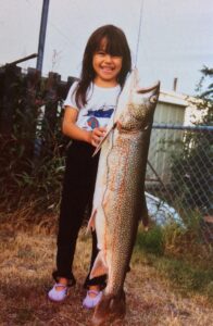 Photo of Dr. Tuma as a child holding beside a large fish