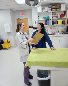 A veterinarian chatting and laughing with a vet tech.